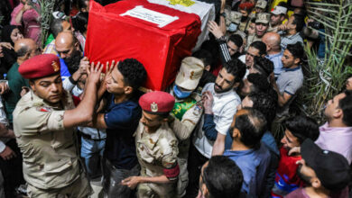 Mourners and soldiers carry the casket of one of 11 Egyptian soldiers killed in an attack