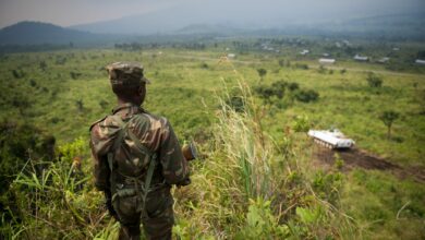 A soldier from the Armed Forces of the Democratic Republic of the Congo (FARDC) stands guard on a hill overlooking a United Nations tank position near the village of Kibumba I, around 20km from the city of Goma in the Democratic Republic of the Congo's restive North Kivu province on July 11, 2012.