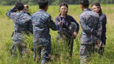 Three female student pilots from the Royal Thai Air Force listening to their instructors on the field