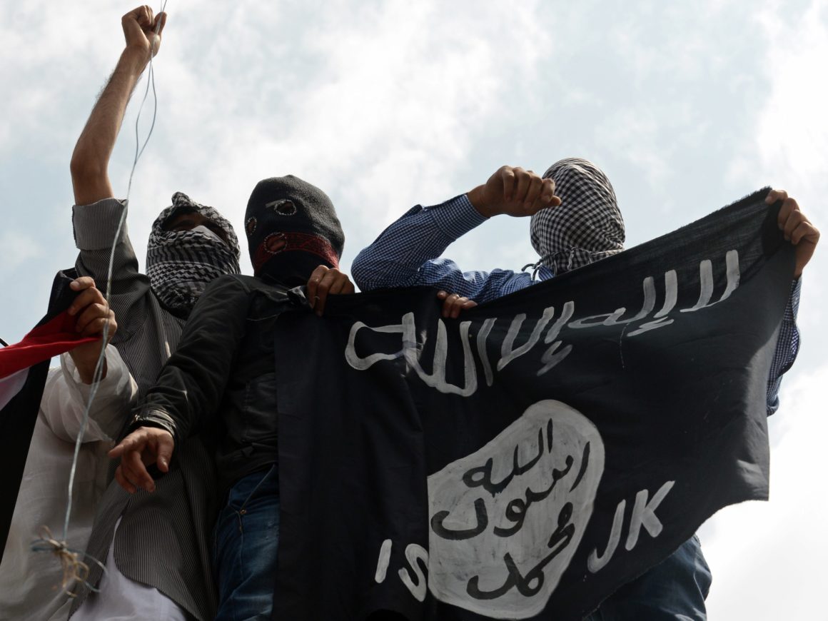 Islamic State supporters hold up the caliphate's flag