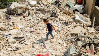 A Palestinian boy walks among houses that were destroyed in Israeli air strikes in Jenin refugee camp in the West Bank