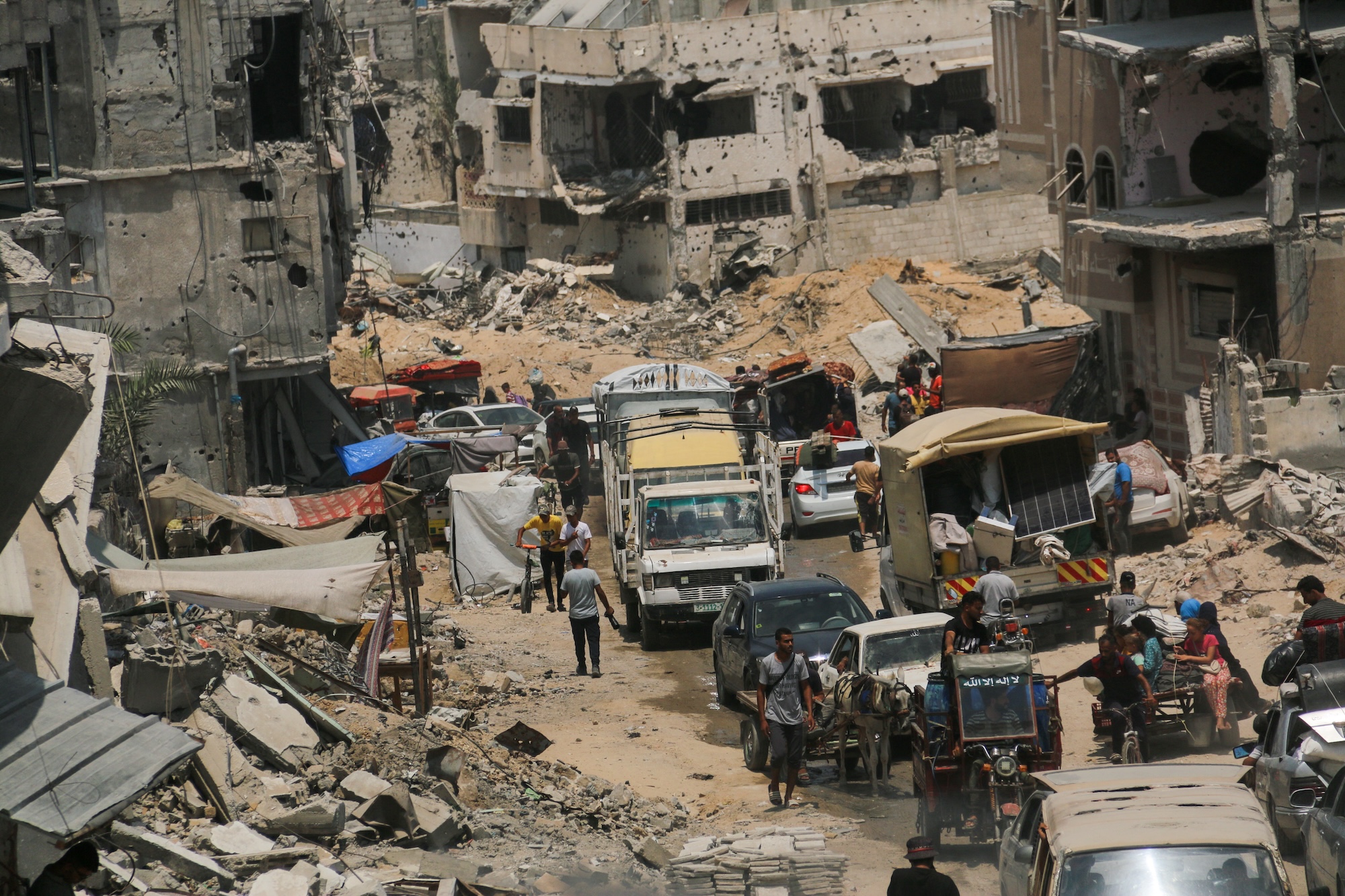 Displaced Palestinians flee their homes with their belongings in the city of Khan Yunis, in the southern Gaza Strip, July 2024