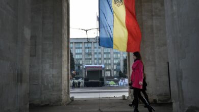 People walk under the Triumph Arch in Chisinau, Moldova.