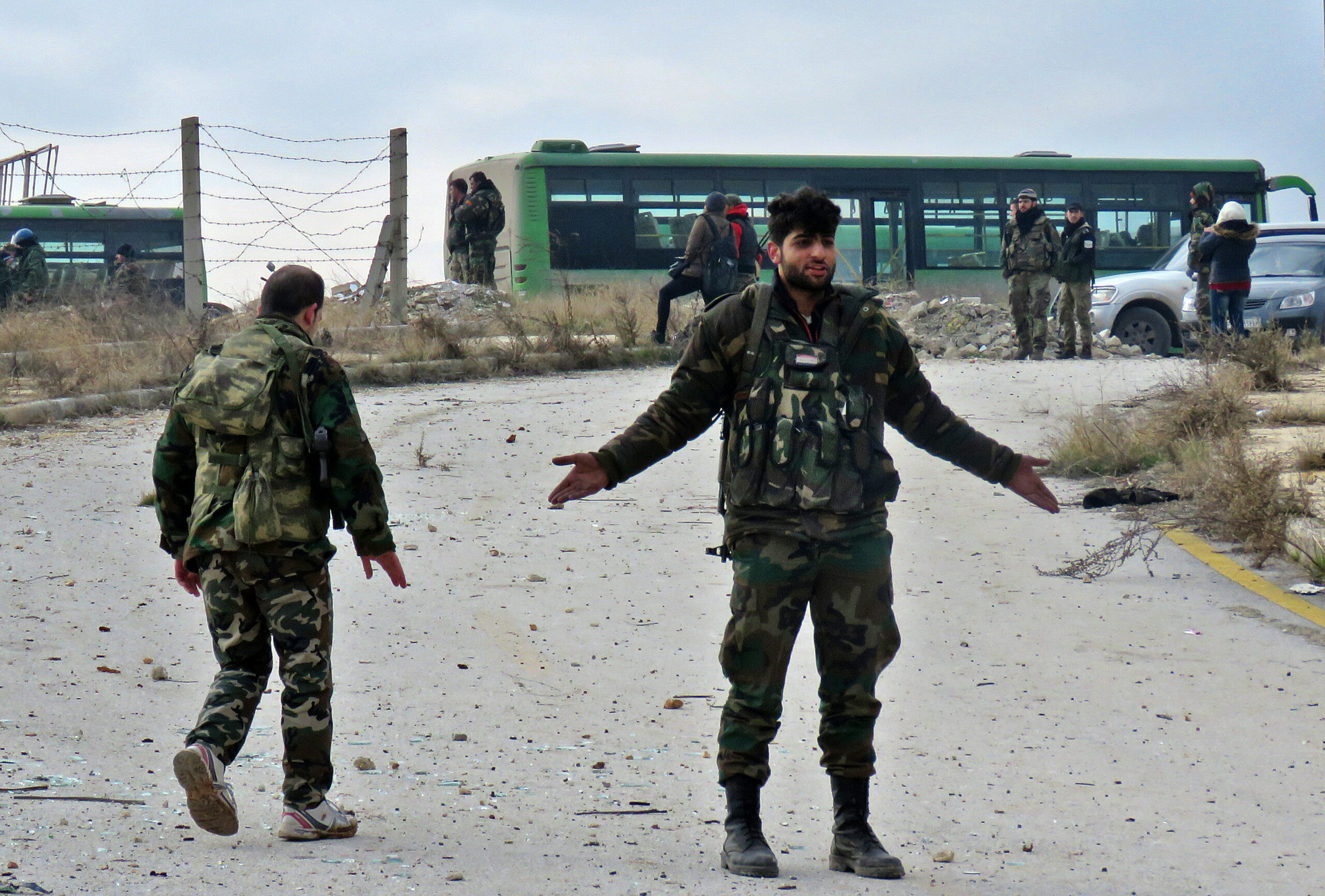 A Syrian soldier gestures during the evacuation of insurgents from a rebel-held area of Aleppo toward rebel-held territory in the west of Aleppo province