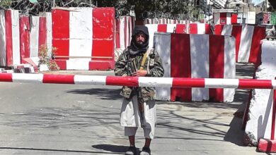 A Taliban fighter stands guard at the entrance of the police headquarters in Ghazni on August 12, 2021