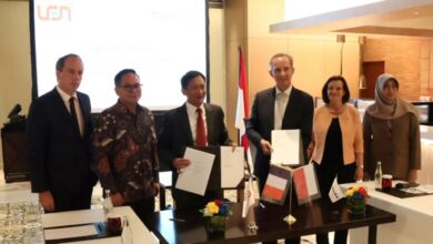 Six personnel from Thales and PT Len Industri stand close during a photo op, with the two in the middle holding what appears to be the papers for the joint venture deal.