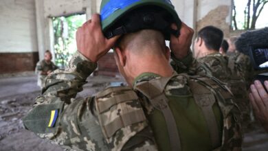 A Shkval (Squall) Battalion serviceman is holding a helmet during drills in Ukraine