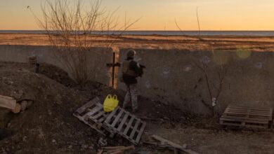 Ukrainian servicemen stand guard at a position next to the Dnipro River