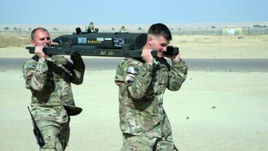 US Army soldiers transporting an M299 launcher rail to an MQ-9 Reaper