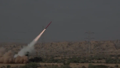 A Fatah-II missile is launched in a plains. It's seen blasting off to the northeast. The plains have green bushes scattered across its yellow sands.